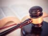 A judge's gavel with an open law book in the background.