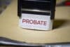 A small sign on a desk that reads "Probate" in red on a white background.