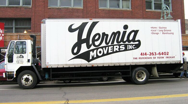 A photo of a Hernia Movers truck parked in front of a building.